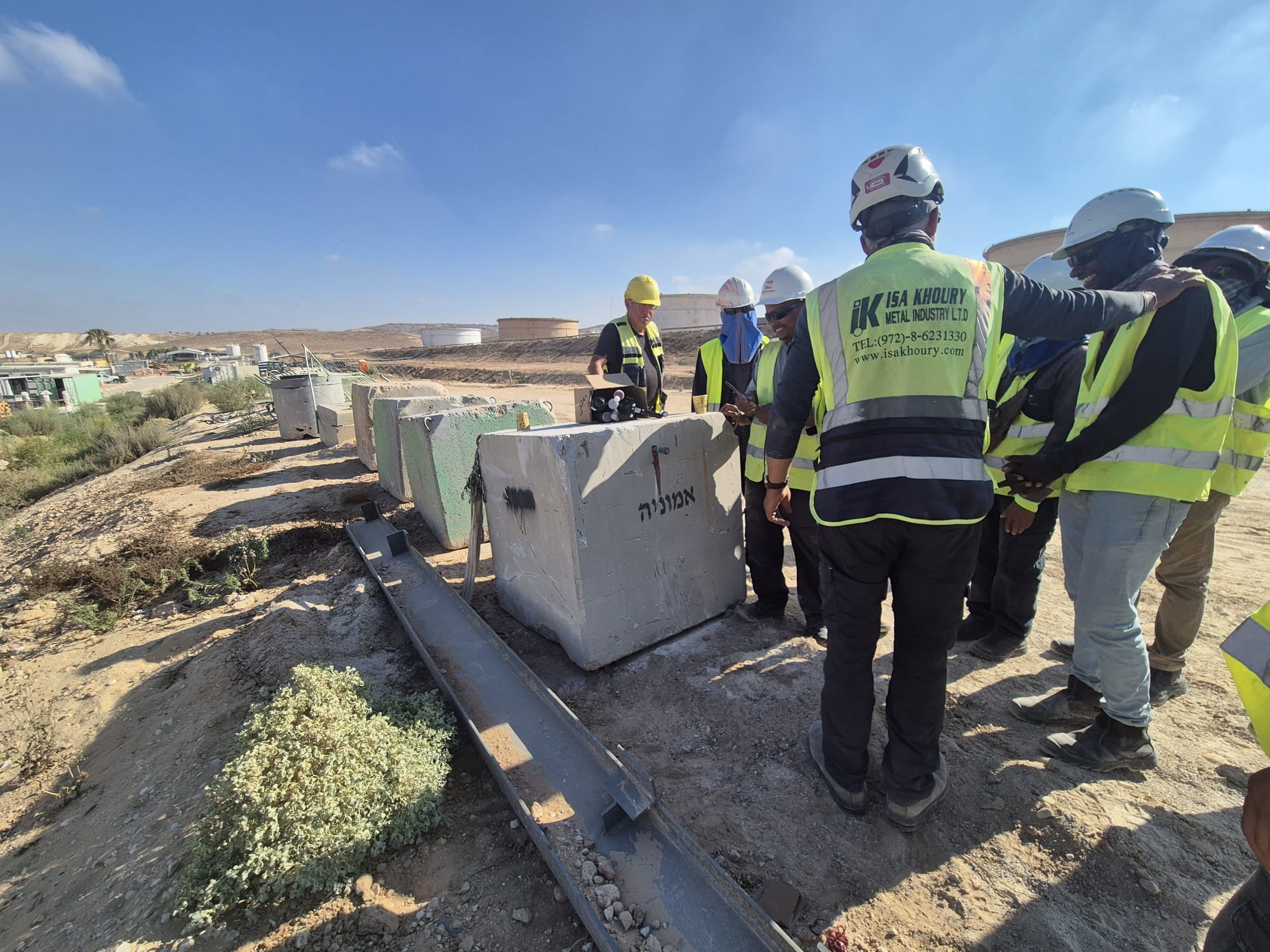 קבוצת מהנדסים באתר בנייה עם אביזרי בטיחות וקסדות.