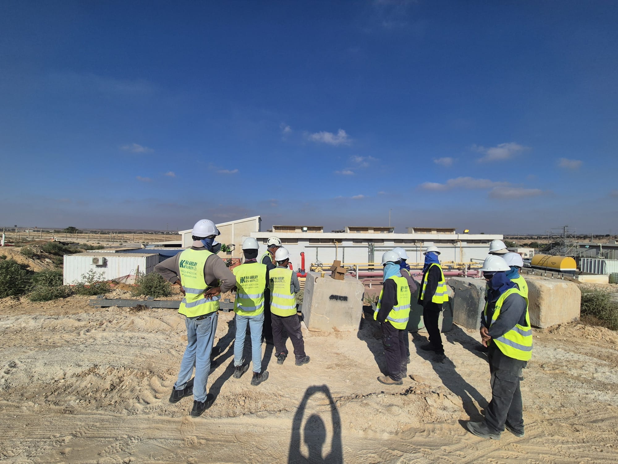 קבוצת עובדים באתר בנייה של אדיט בע"מ עם ציוד מגן.