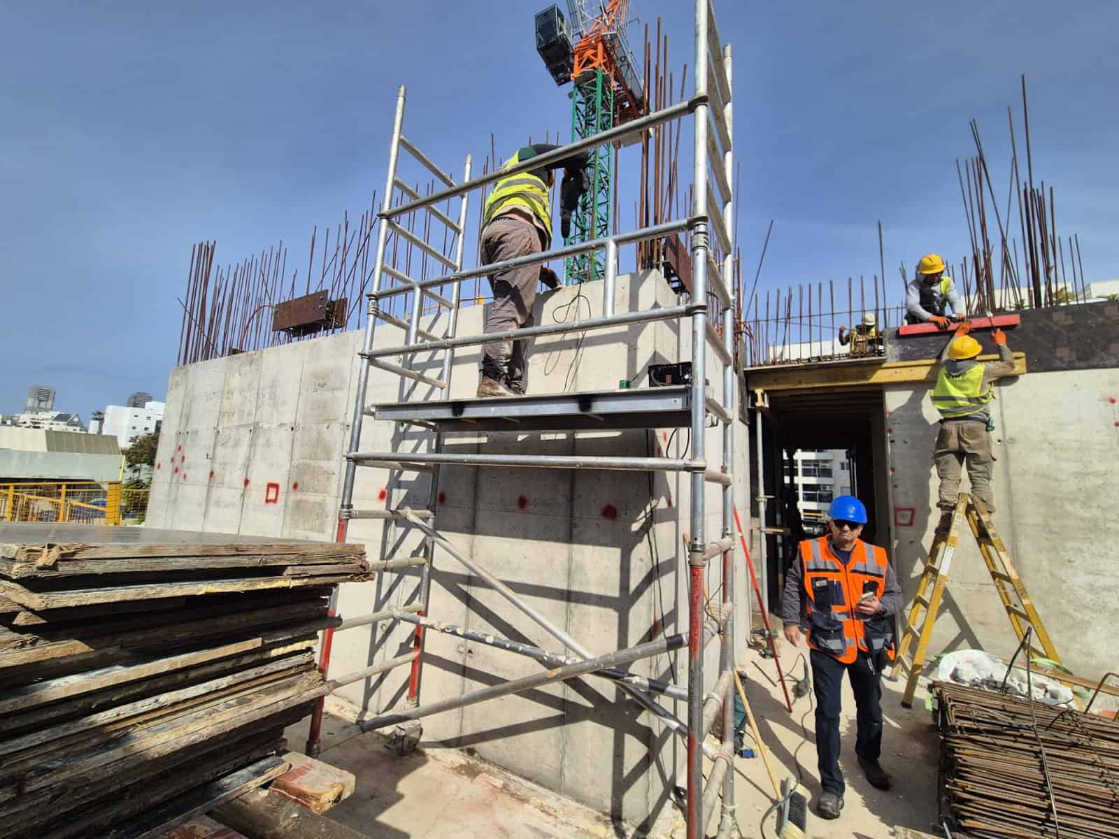 עובדי בניין באתר בנייה של אדיט בע"מ עם ציוד בטיחות.
