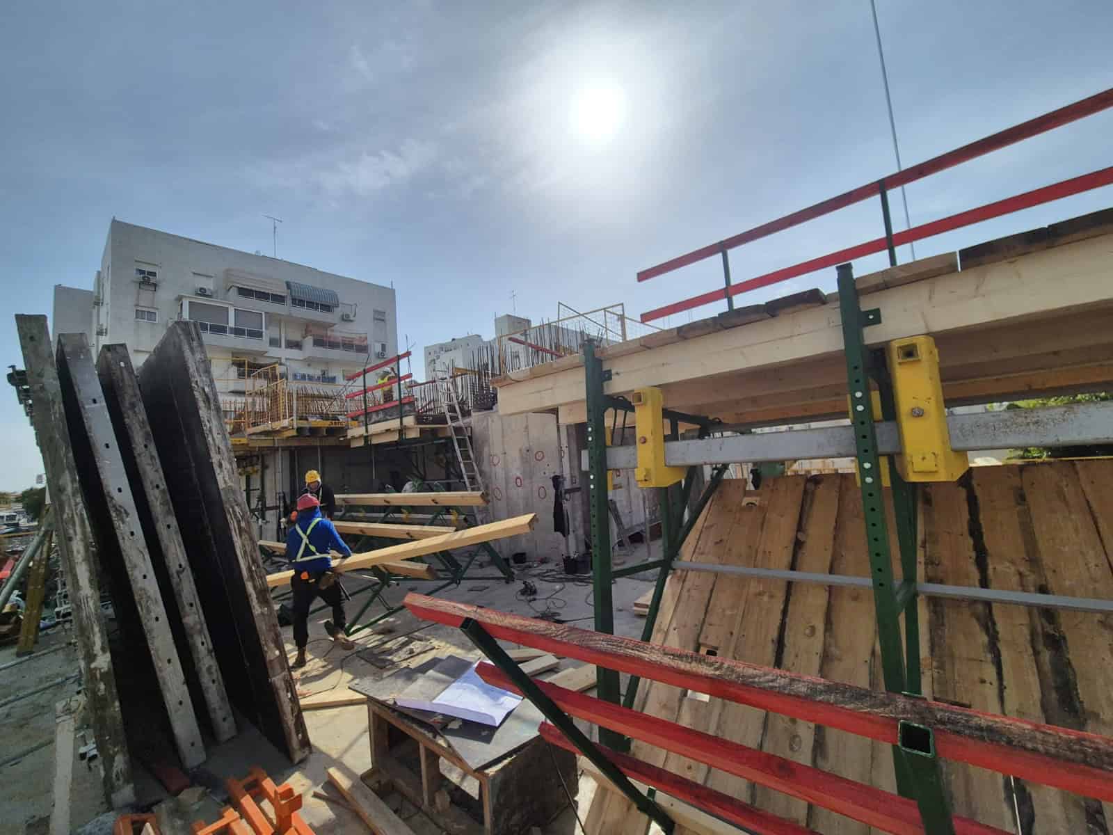 עובדי בניין באתר בנייה של אדיט בע"מ עם ציוד ומבנה בבנייה.