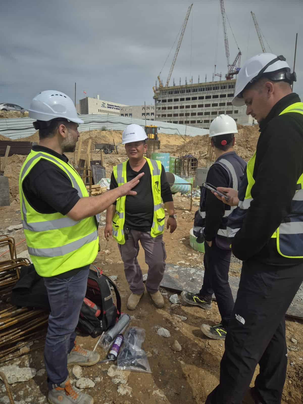 קבוצת מהנדסים באתר בנייה של אדיט בע"מ עם ציוד בטיחות.