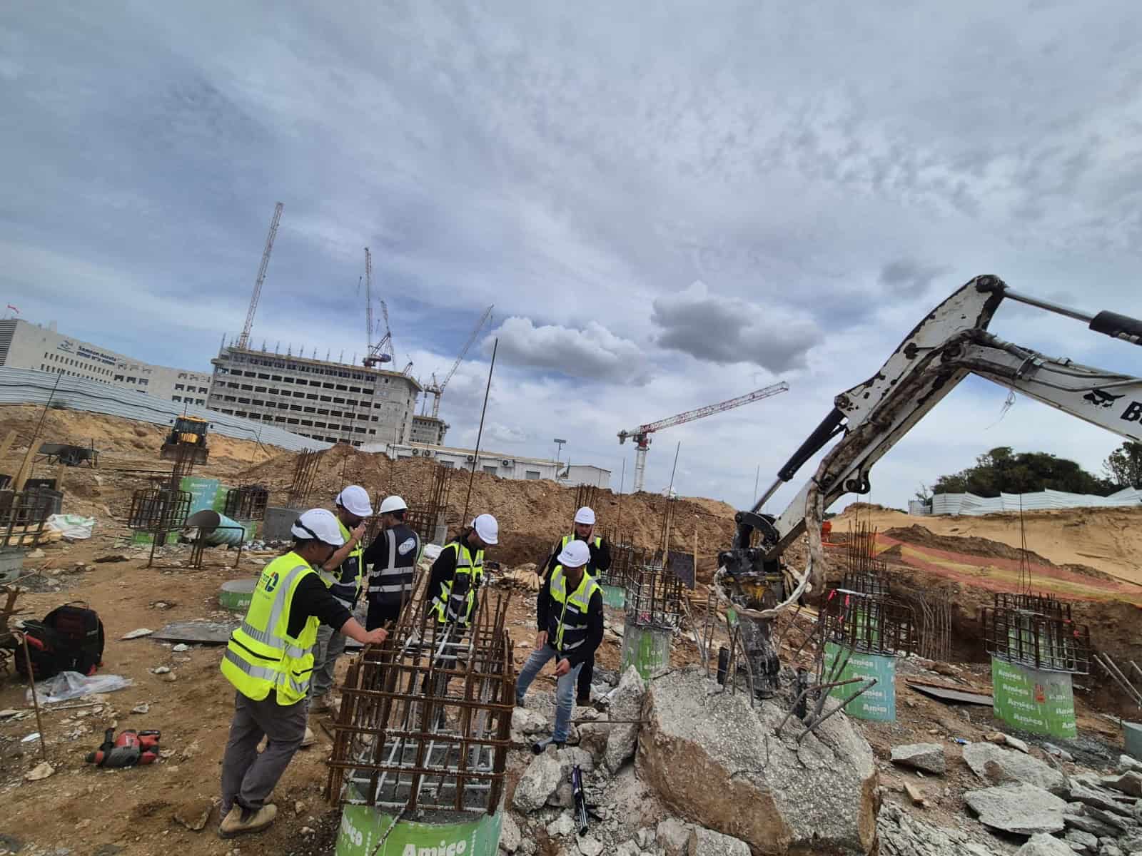 עובדי בניין עם קסדות וצהוב על אתר בנייה של אדיט בע"מ.