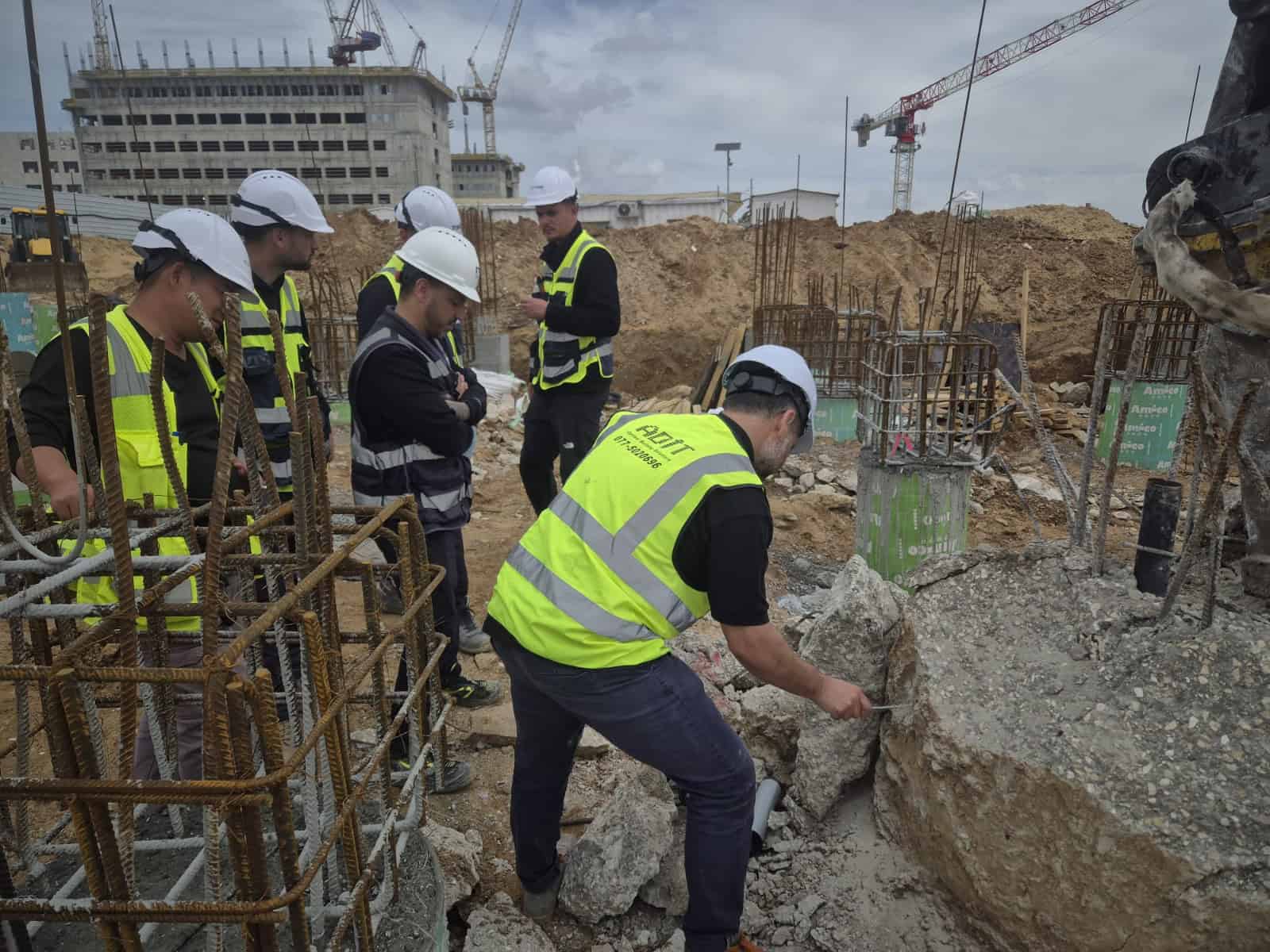 קבוצת מהנדסים באתר בנייה עם ציוד מגן, בוחנים את העבודה.