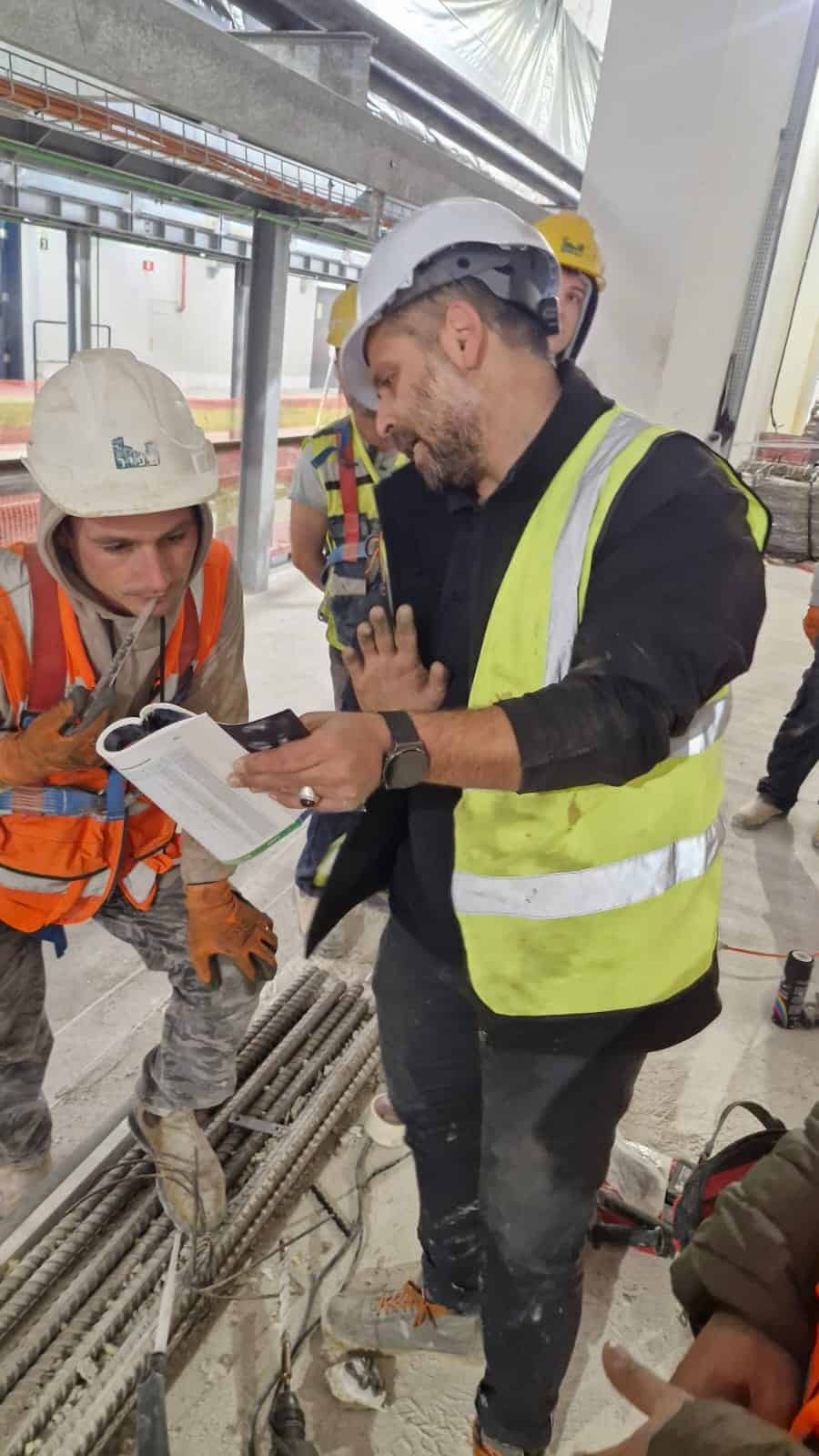 מהנדס ומפקח בנייה בודק מסמכים באתר בנייה של אדיט בע״מ.