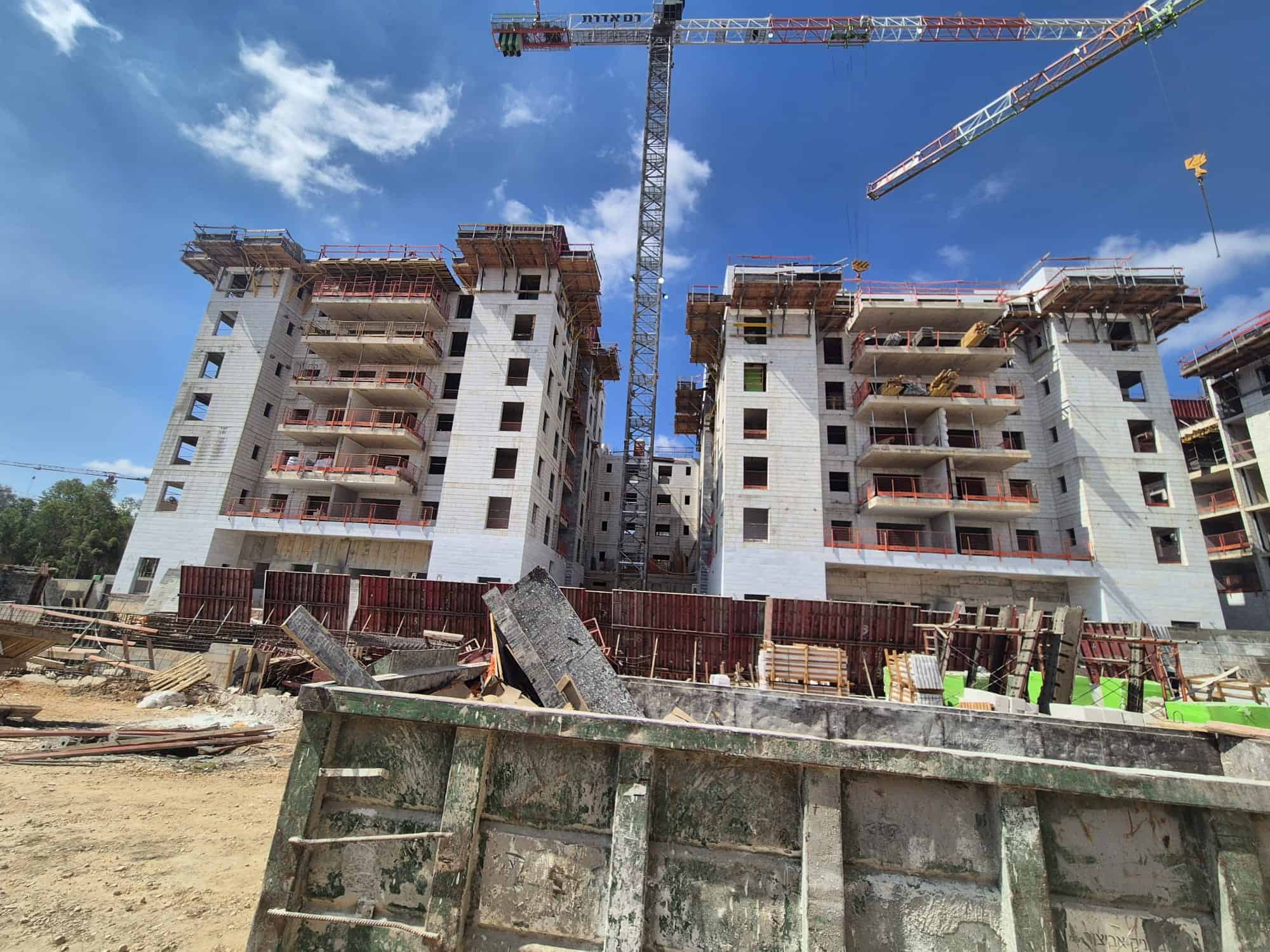 אתר בנייה עם בניינים מתקדמים ומנוף בנייה בשימוש באדיט בע"מ.