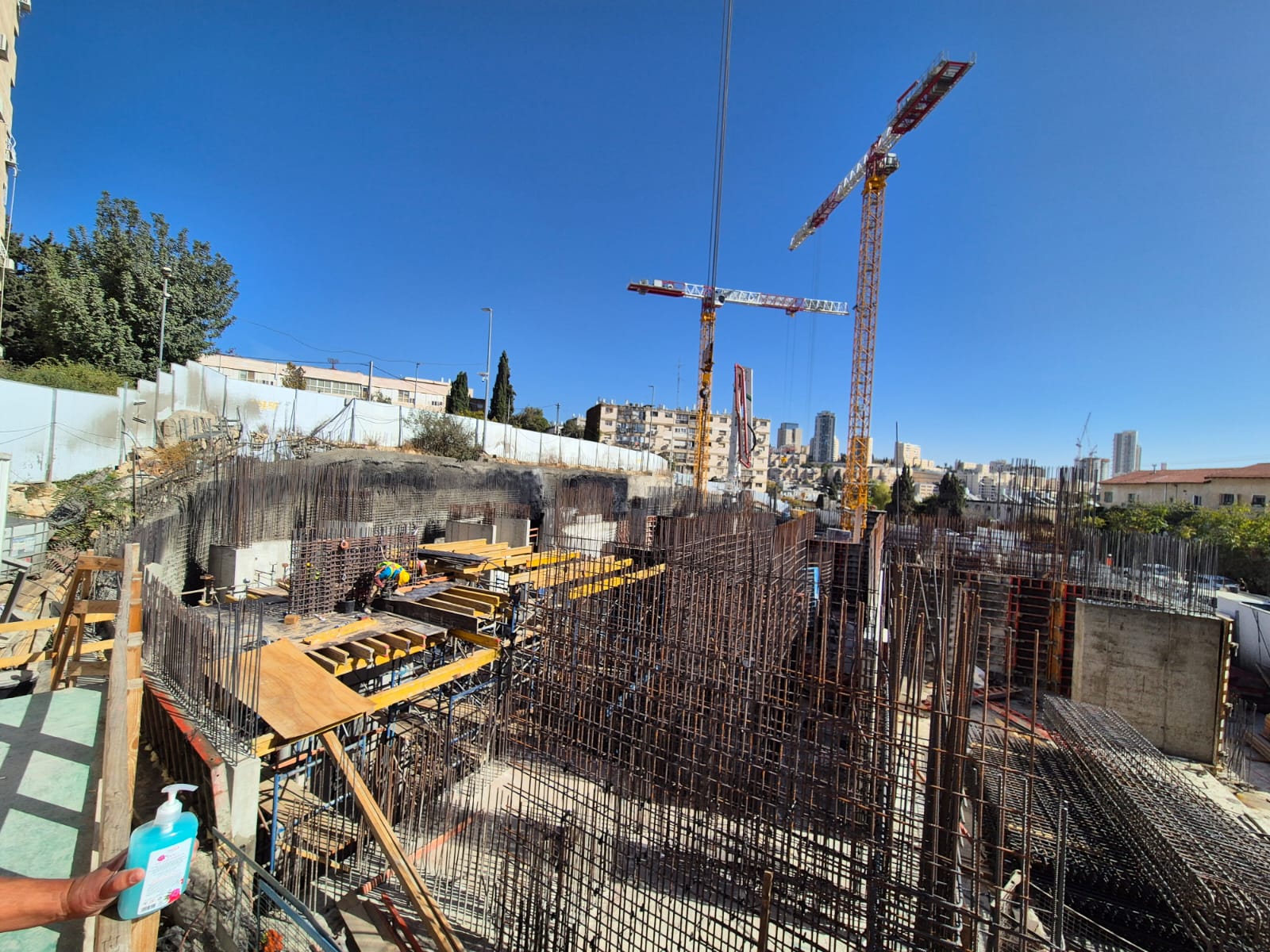 אתר בנייה עם מנופים ועובדים, תהליך בנייה מתקדם.