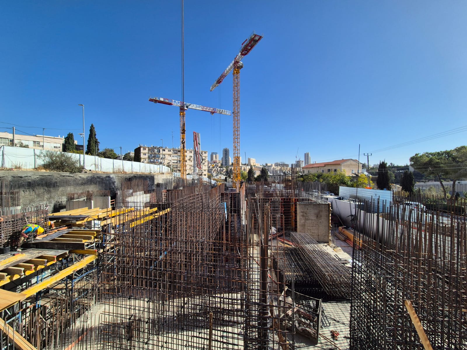 אתר בנייה עם מנופים וברזל לבניית מבנה חדש.