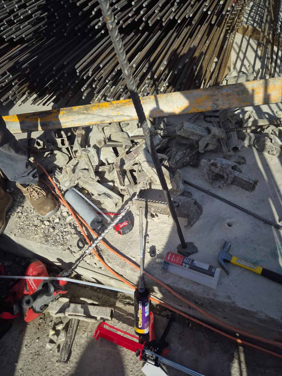 כלי עבודה ומכשירים באתר בנייה עם אבנים וציוד בטיחות.