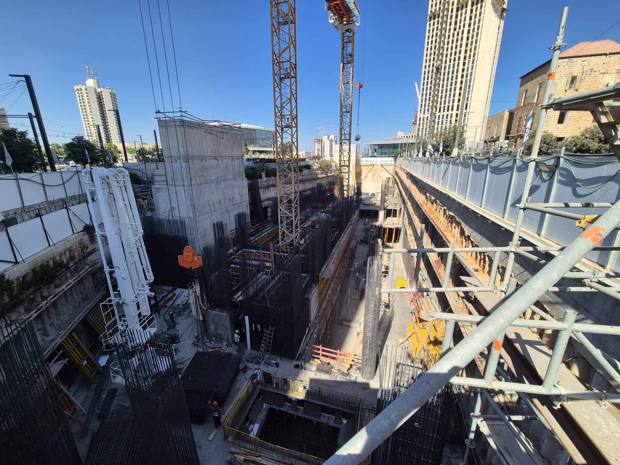 אתר בנייה פעיל עם מנופים ועובדים, עיר מודרנית בתל אביב.